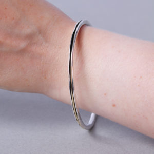 Medium width forged silver bangle, with spinning gold ring detail.